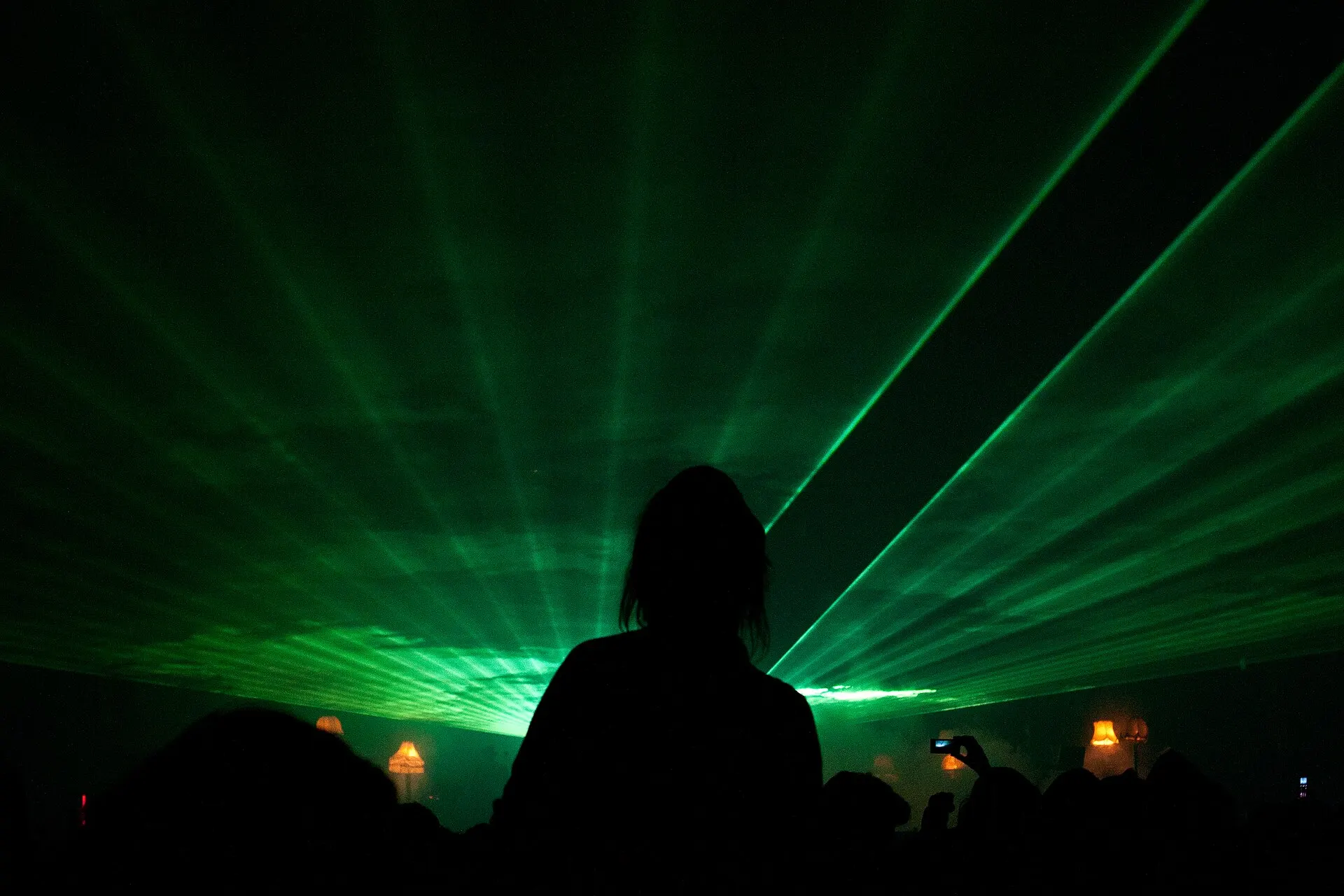 Lasers verdes sobre o público em frente ao palco